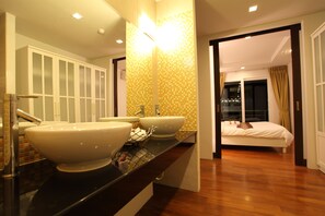 A modern bathroom with two large sinks, a mirror, and a shower area.