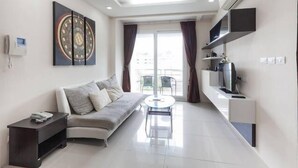 Un salon moderne avec un canapé, une table basse et un téléviseur fixé au mur.