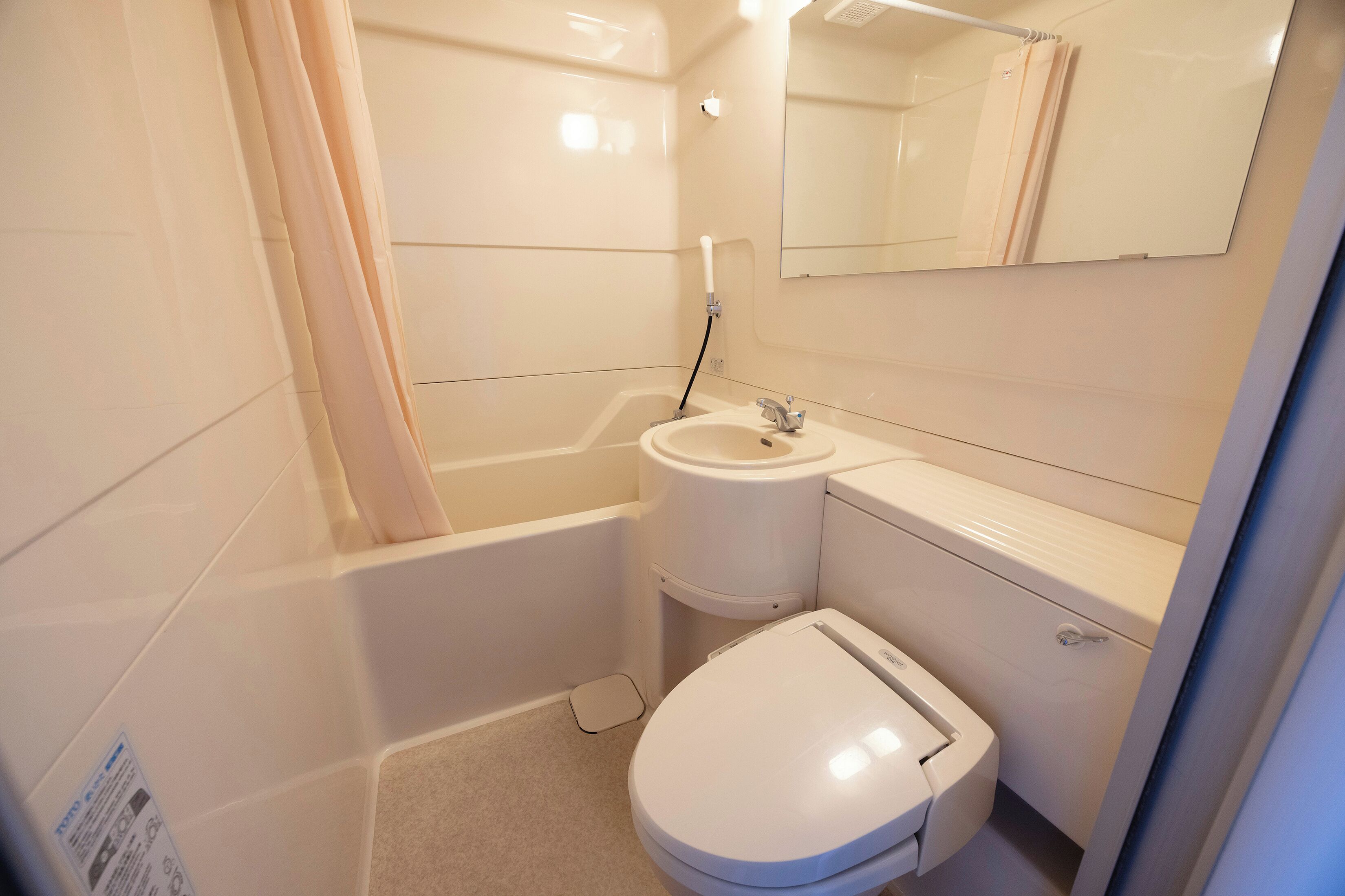 Un baño pequeño y funcional con inodoro, lavamanos y bañera.