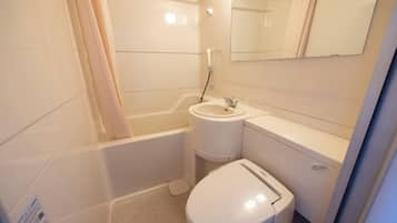 A small, compact bathroom with a toilet, sink, and bathtub.