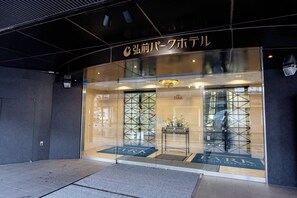 A hotel entrance with a glass facade, a reception desk, and a sign above the door. - Hirosaki Park Hotel (Hirosaki)