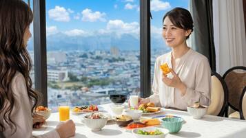 Una mesa de comedor con diversos platos y un vaso de jugo de naranja.