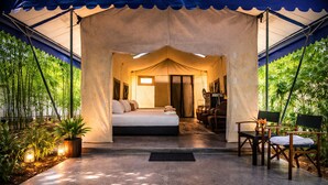 A tented accommodation with a bed, seating area, and a small desk. - The Orchard Resort & Spa Melaka (Alor Gajah)