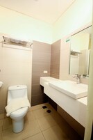 A small, modern bathroom with a toilet, sink, and mirror.