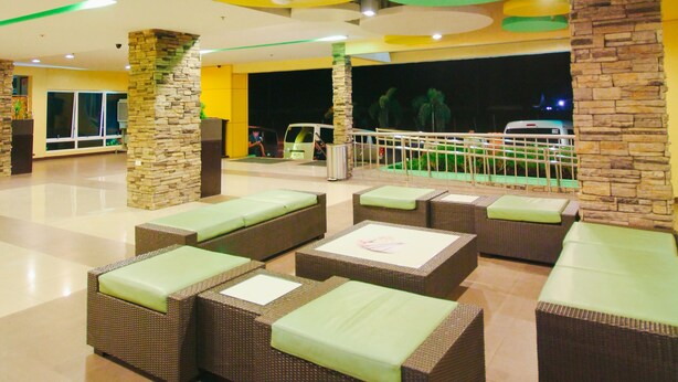 A spacious indoor area with multiple seating arrangements and a view of a night scene outside.