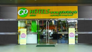 A hotel entrance with a prominent sign reading "GO HOTELS" and a website address. There are two banners on either side of the entrance, one stating "NOW OPEN!" and the other "NOW OPEN!". - Go Hotels Iloilo (Iloilo)