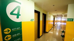 A hotel corridor with directional signs and emergency equipment. - Go Hotels Iloilo (Iloilo)