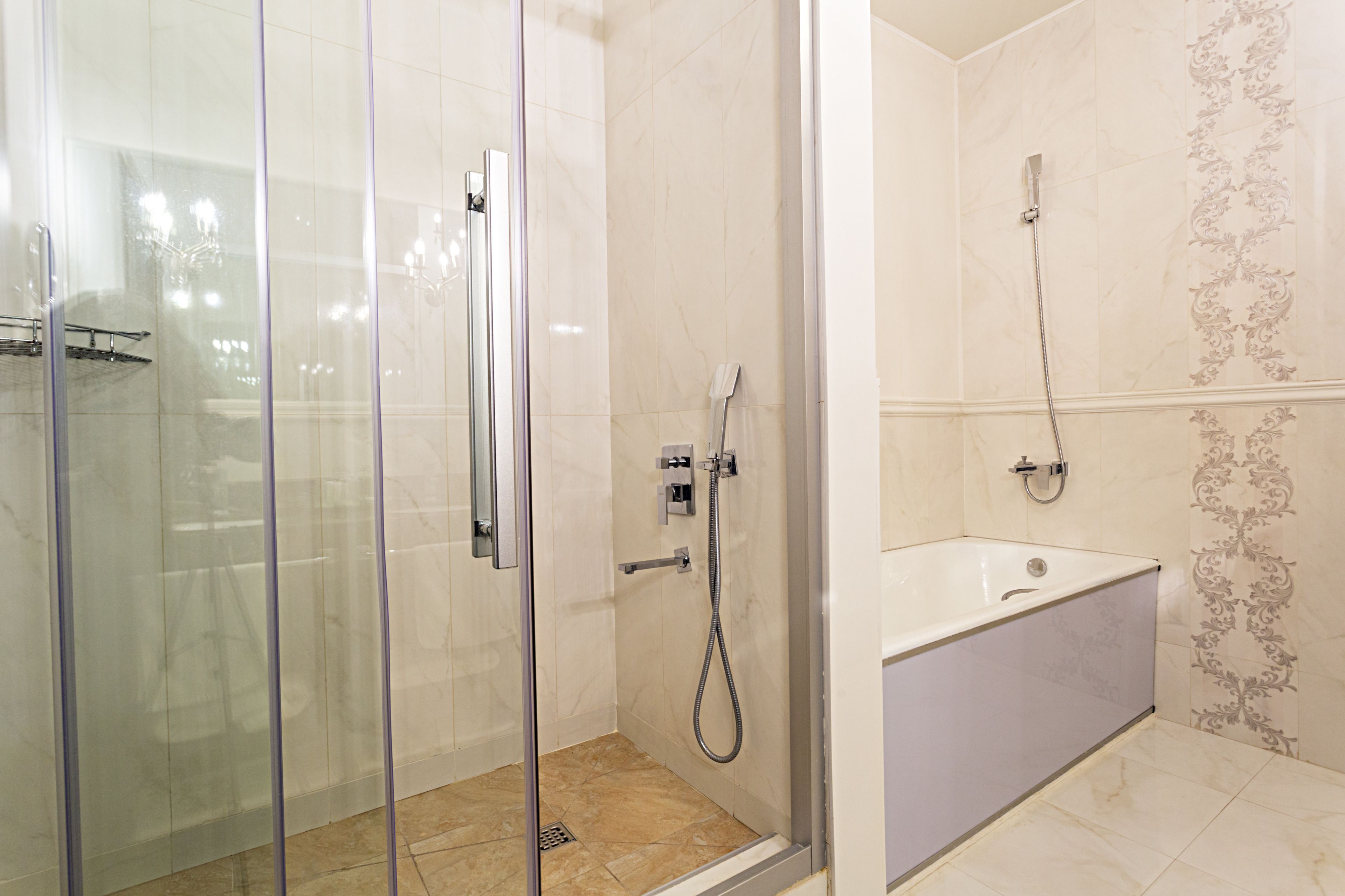 Ein modernes Badezimmer mit einer gläsernen Duschkabine, einer freistehenden Badewanne und einem Waschtisch mit Spiegel.