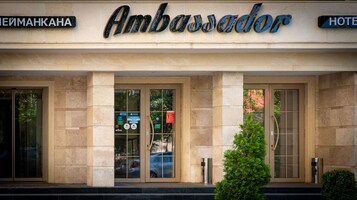 Entrada de hotel con un cartel que dice "Ambassador" y un letrero más pequeño que indica "HOTEL".
