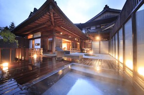 A traditional Japanese building with a wooden deck and a hot spring area. - Fuji Onsenji Yumedono (Fujikawaguchiko)