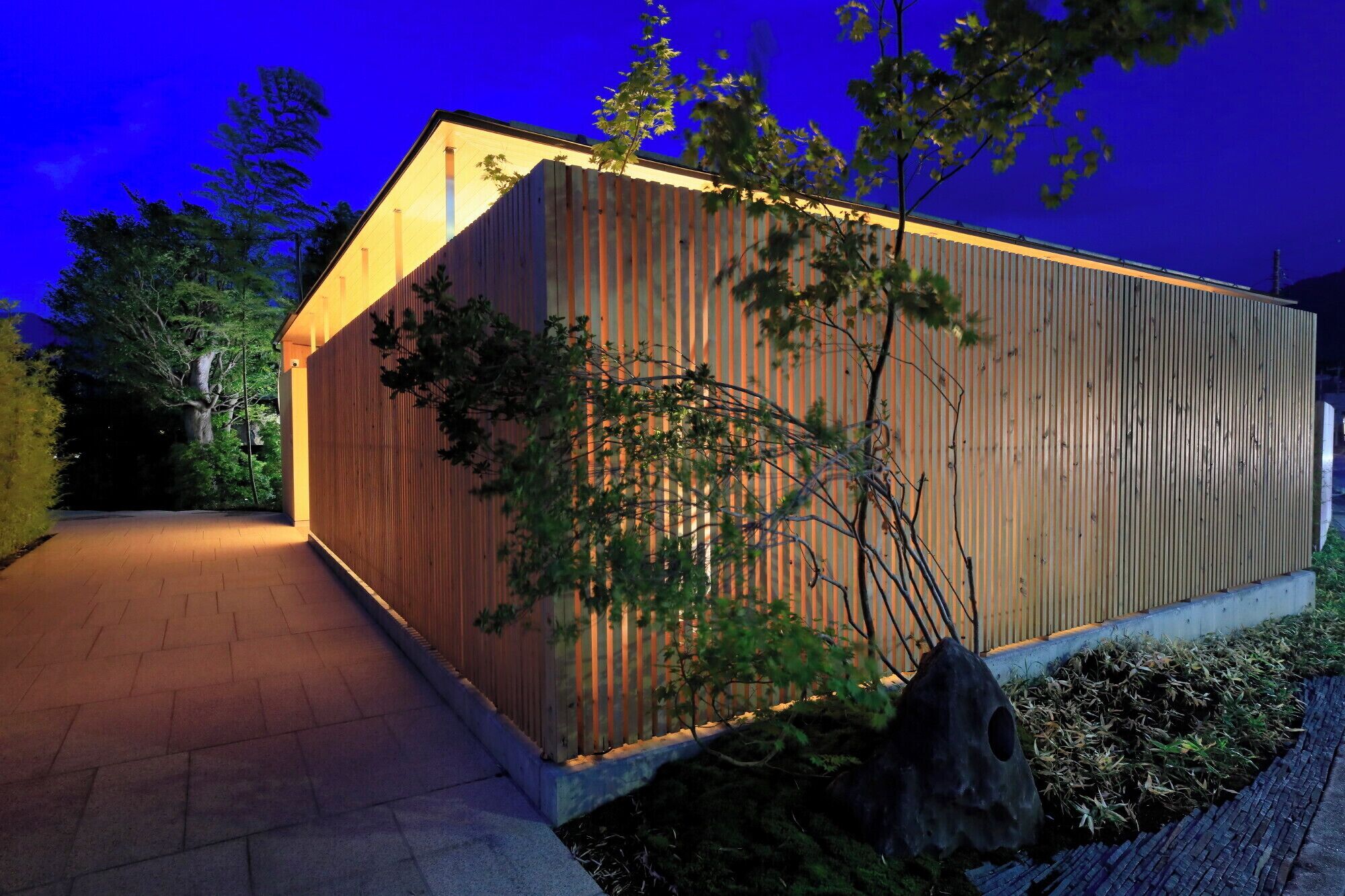 A modern building with a sloped roof and a wooden facade.