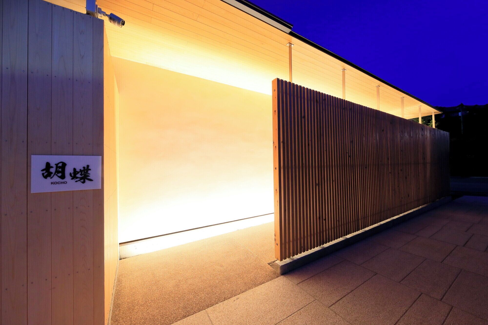 A building with a wooden exterior and a sign with Japanese characters.