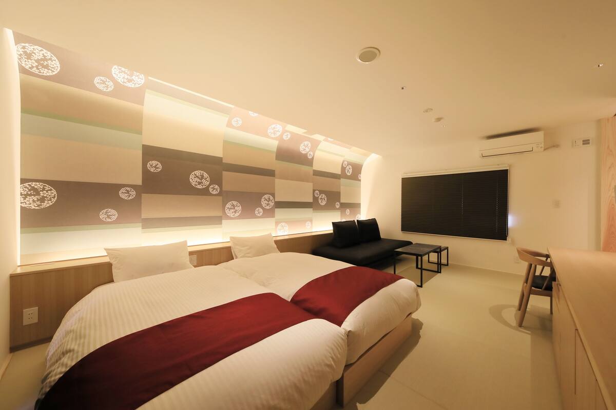 Ein modernes Hotelzimmer mit einem großen Bett, einem Schreibtisch und einem Sessel.