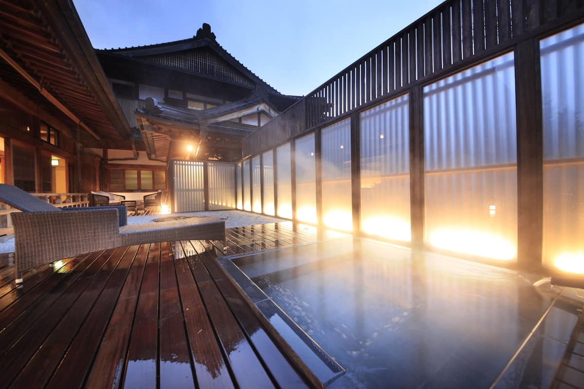 Ein traditionelles japanisches Gebäude mit einer Holterrasse und einem Thermalbadbereich.