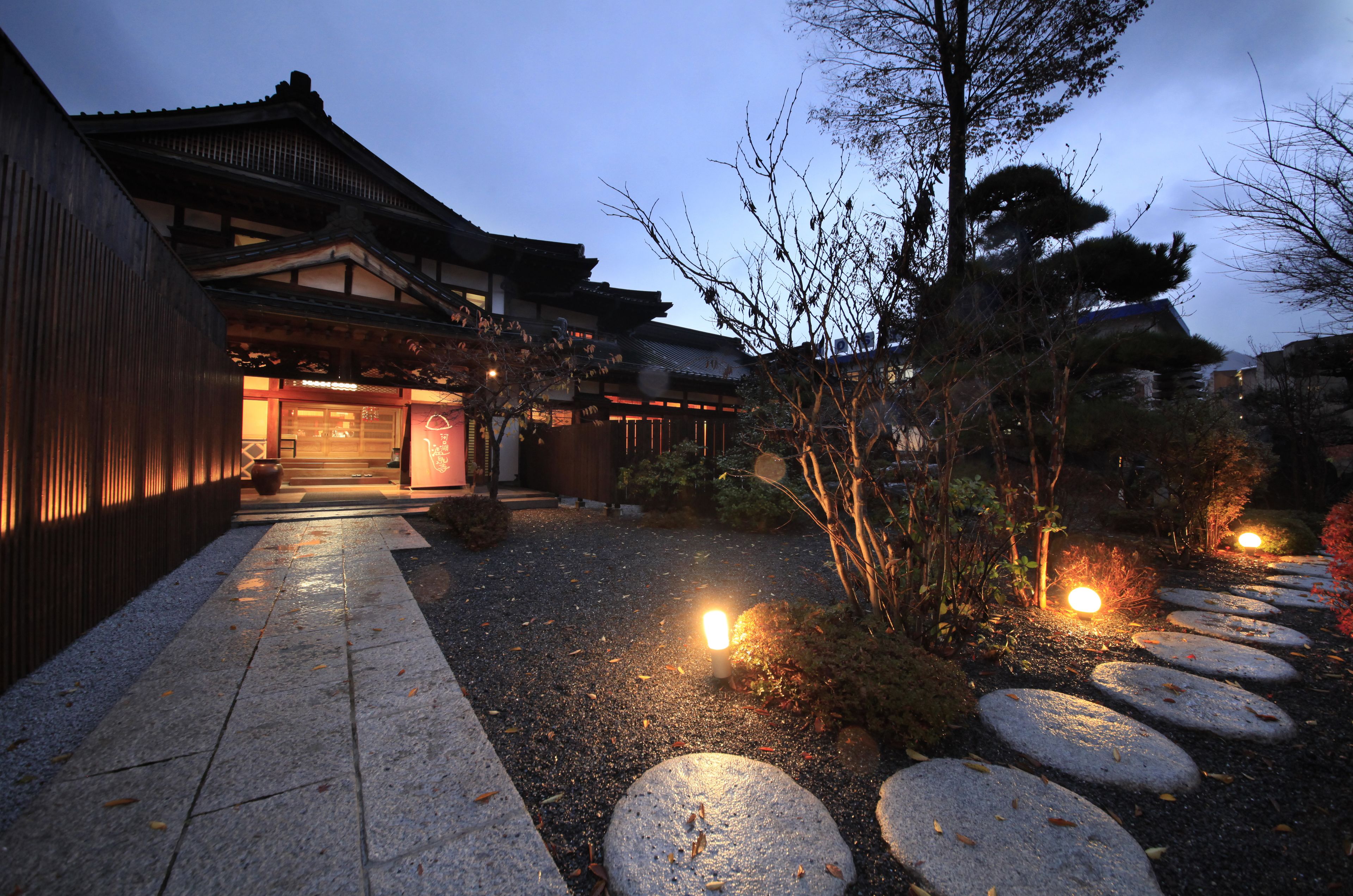 A traditional Japanese building with a stone pathway leading to the entrance.