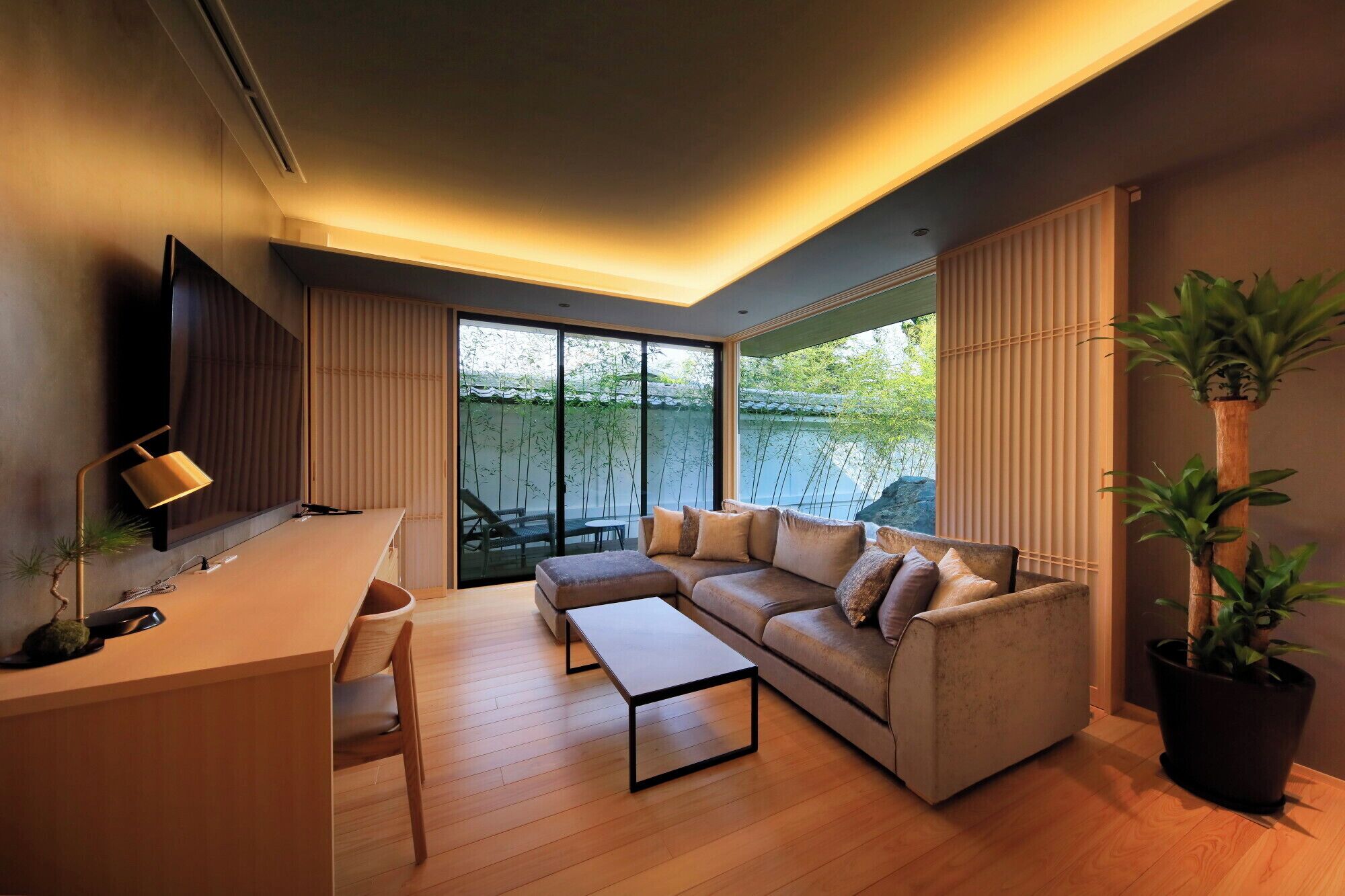 A modern living room with a sofa, coffee table, and a TV mounted on the wall.