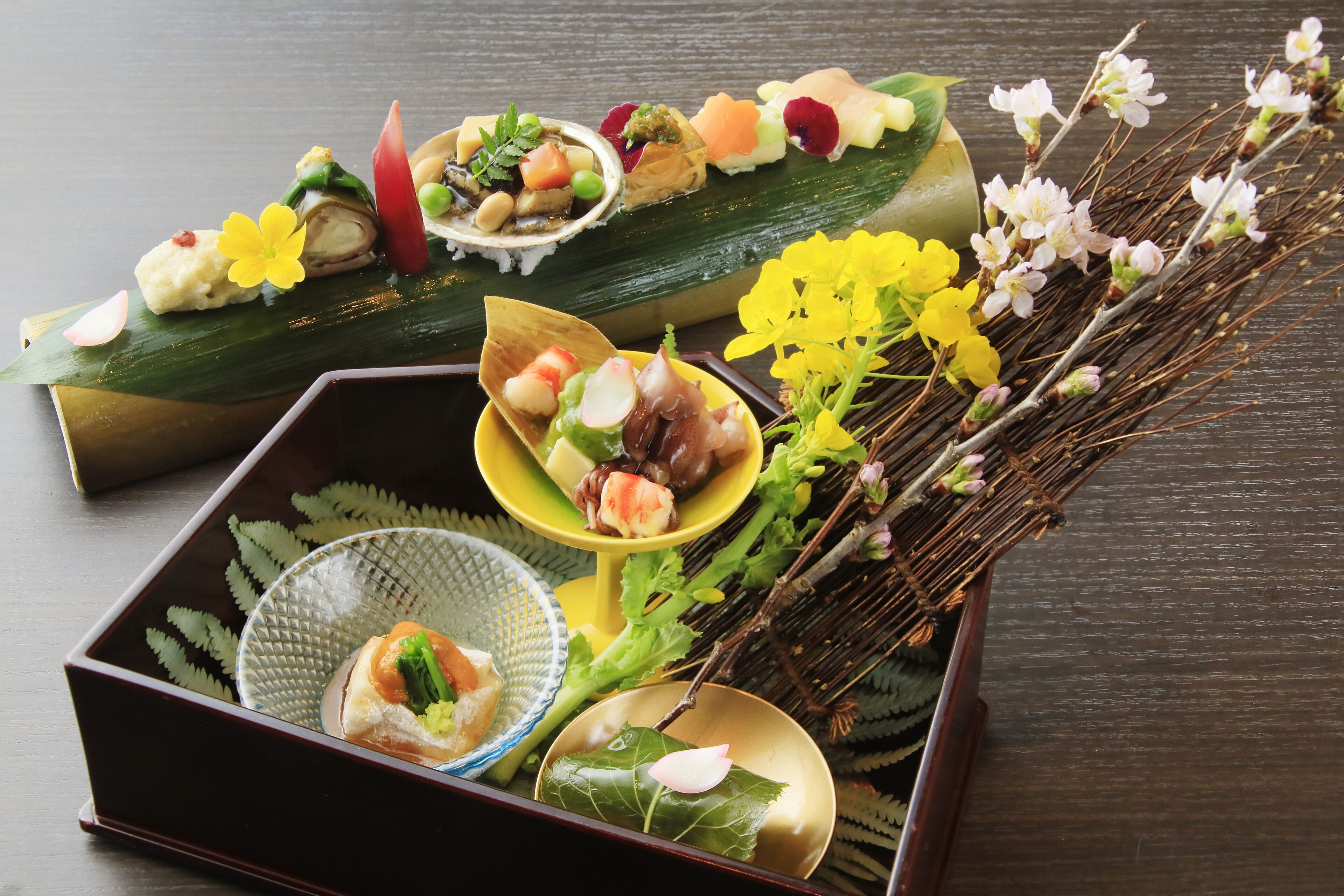 Una comida tradicional japonesa con varios platos dispuestos sobre una mesa de madera.