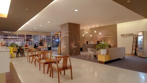 A modern hotel lobby with a reception desk, seating area, and a G2G sign. - Go Hotels Plus Mandaluyong (Mandaluyong)