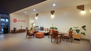 A modern hotel lobby with a reception desk, seating area, and a large plant. - Go Hotels Plus Mandaluyong (Mandaluyong)
