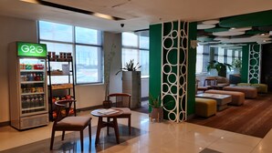 A modern lobby with a vending machine, seating area, and large windows. - Go Hotels Otis - Manila (Manila)