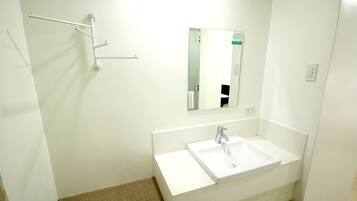 A bathroom with a white sink, a mirror, and a towel rack.