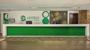 A hotel reception desk with a green and white color scheme, a digital screen, and a reception counter. - Go Hotels Puerto Princesa (Puerto Princesa)