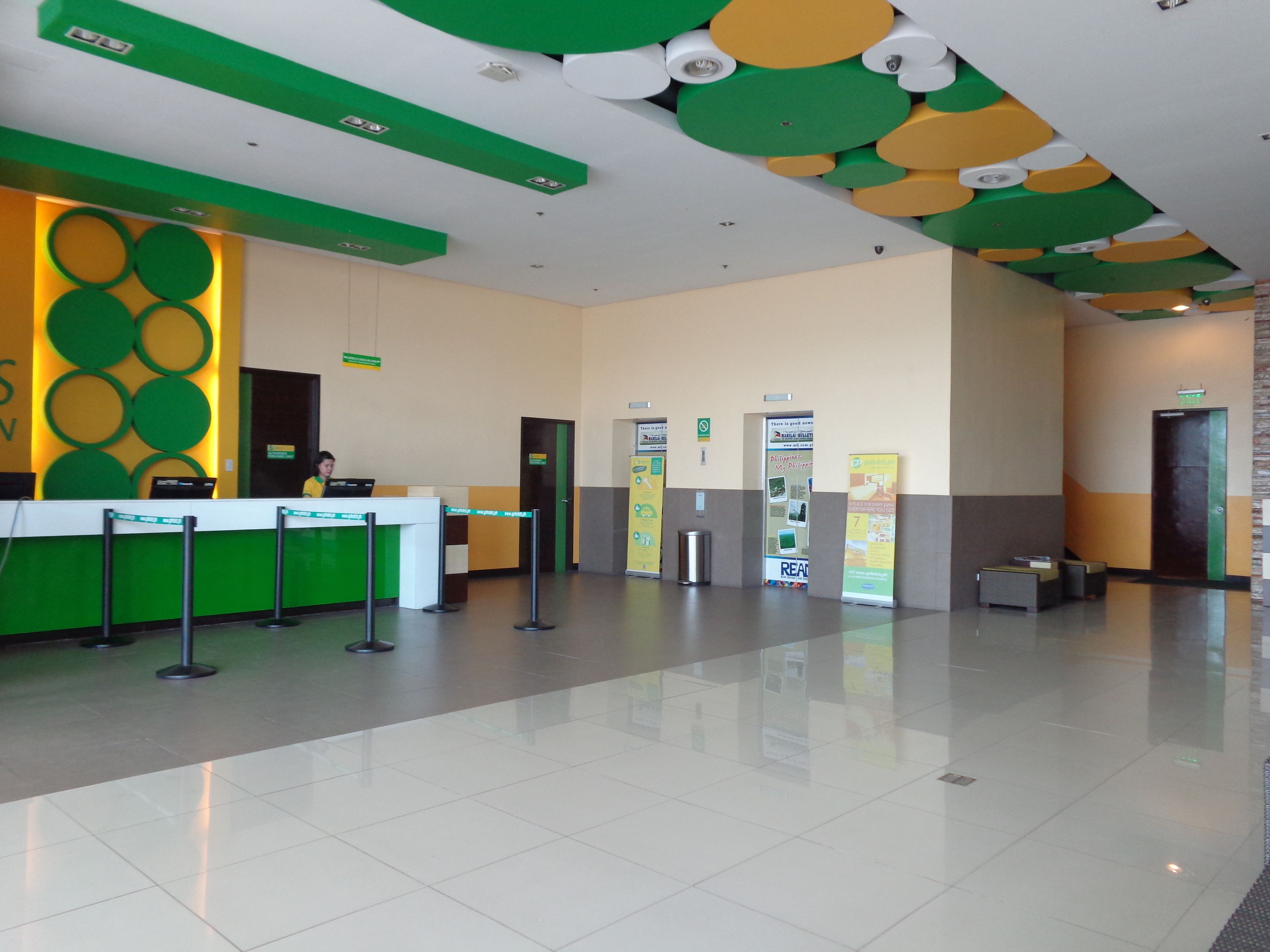 A reception area with a green and white color scheme, a reception desk, and a clean, tiled floor.