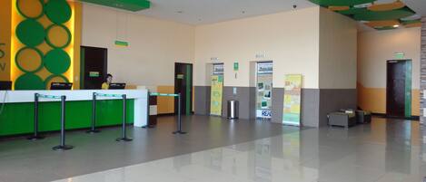 A reception area with a green and white color scheme, a reception desk, and a clean, tiled floor.