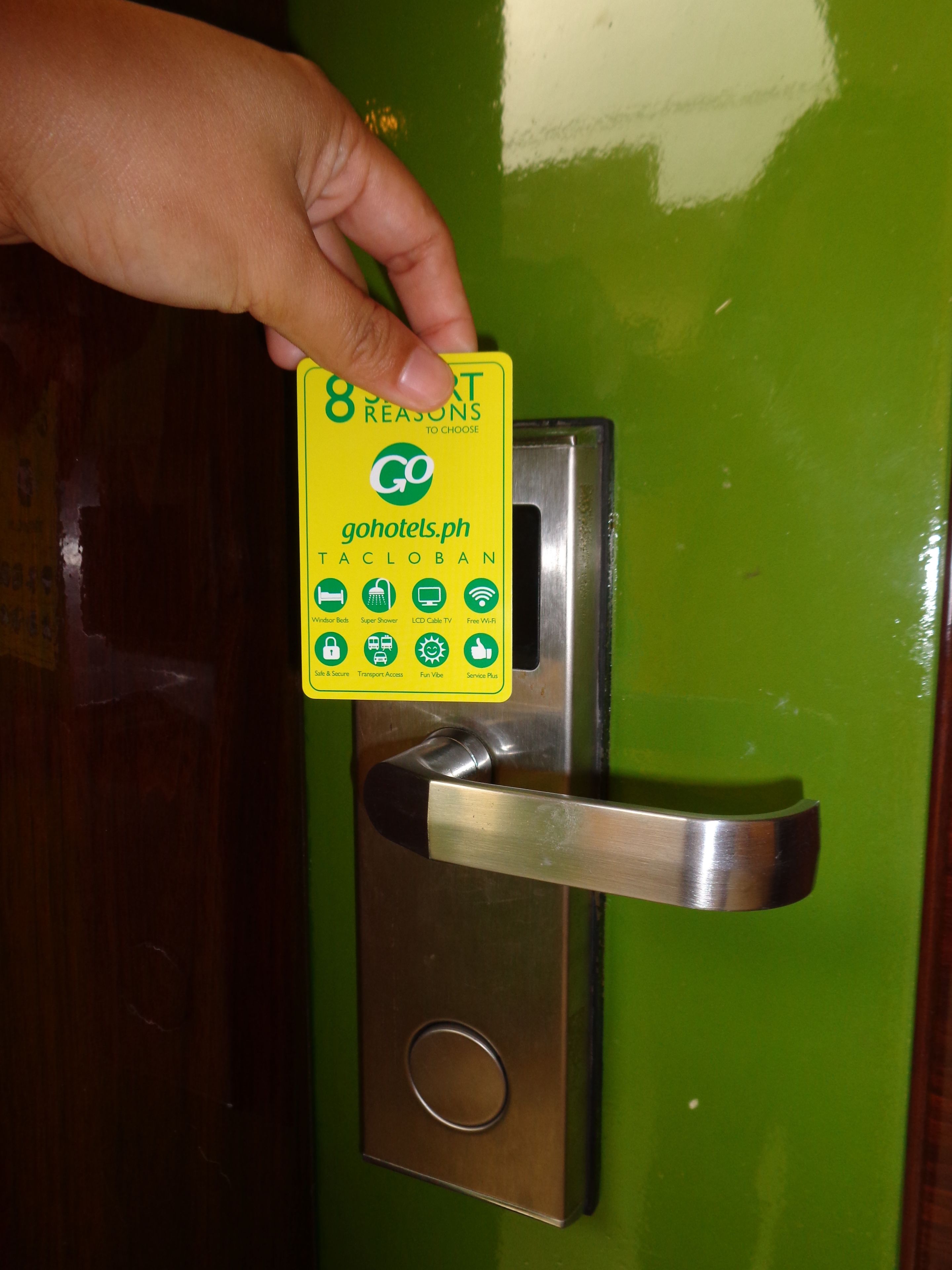 A hand holding a card with amenities listed on a door handle.
