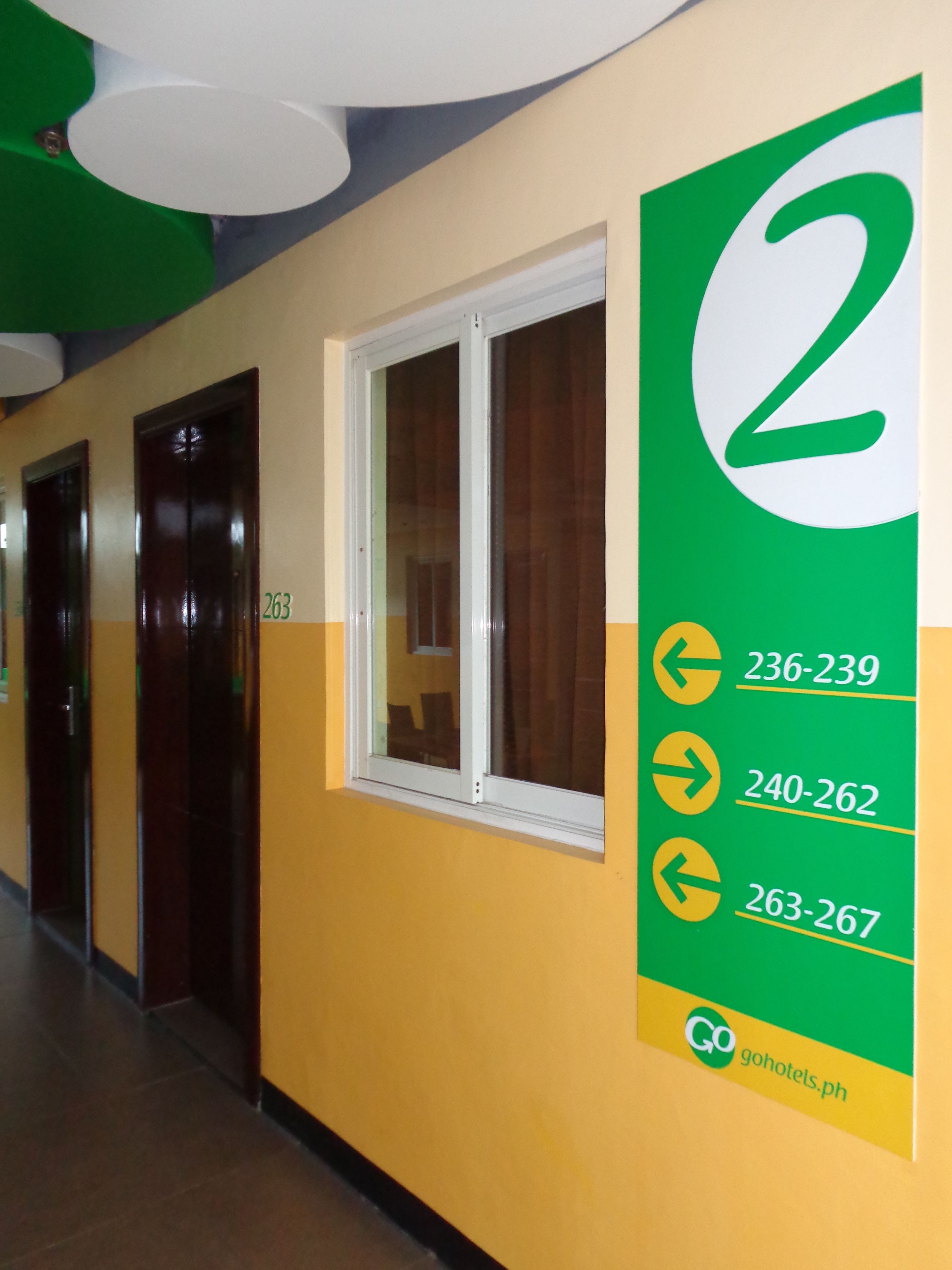 A hallway with doors numbered 263 and 264, and a sign indicating room numbers 236-239, 240-262, and 263-267.