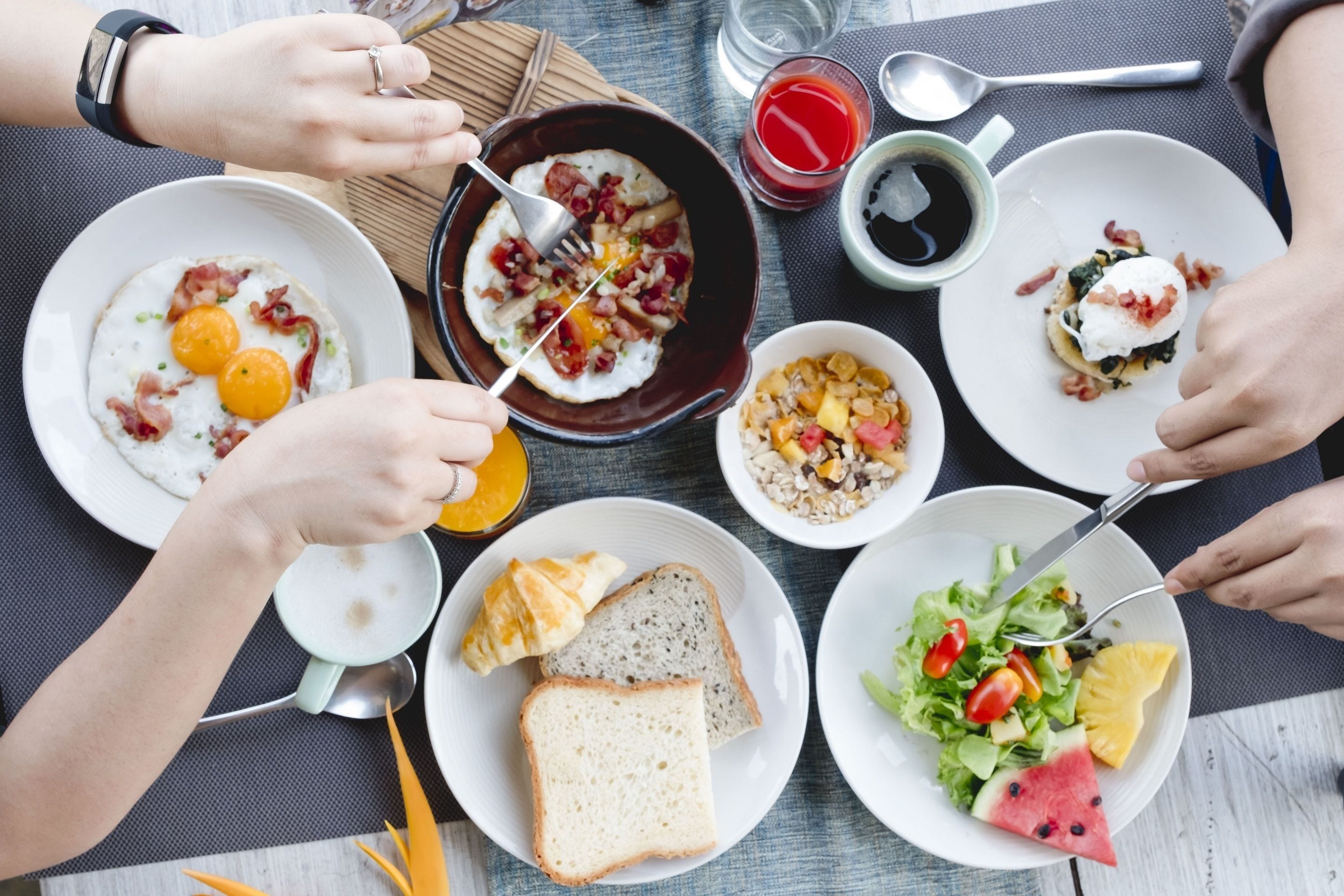 A table with breakfast items including eggs, toast, and a salad.