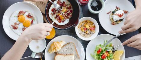 A table with breakfast items including eggs, toast, and a salad.