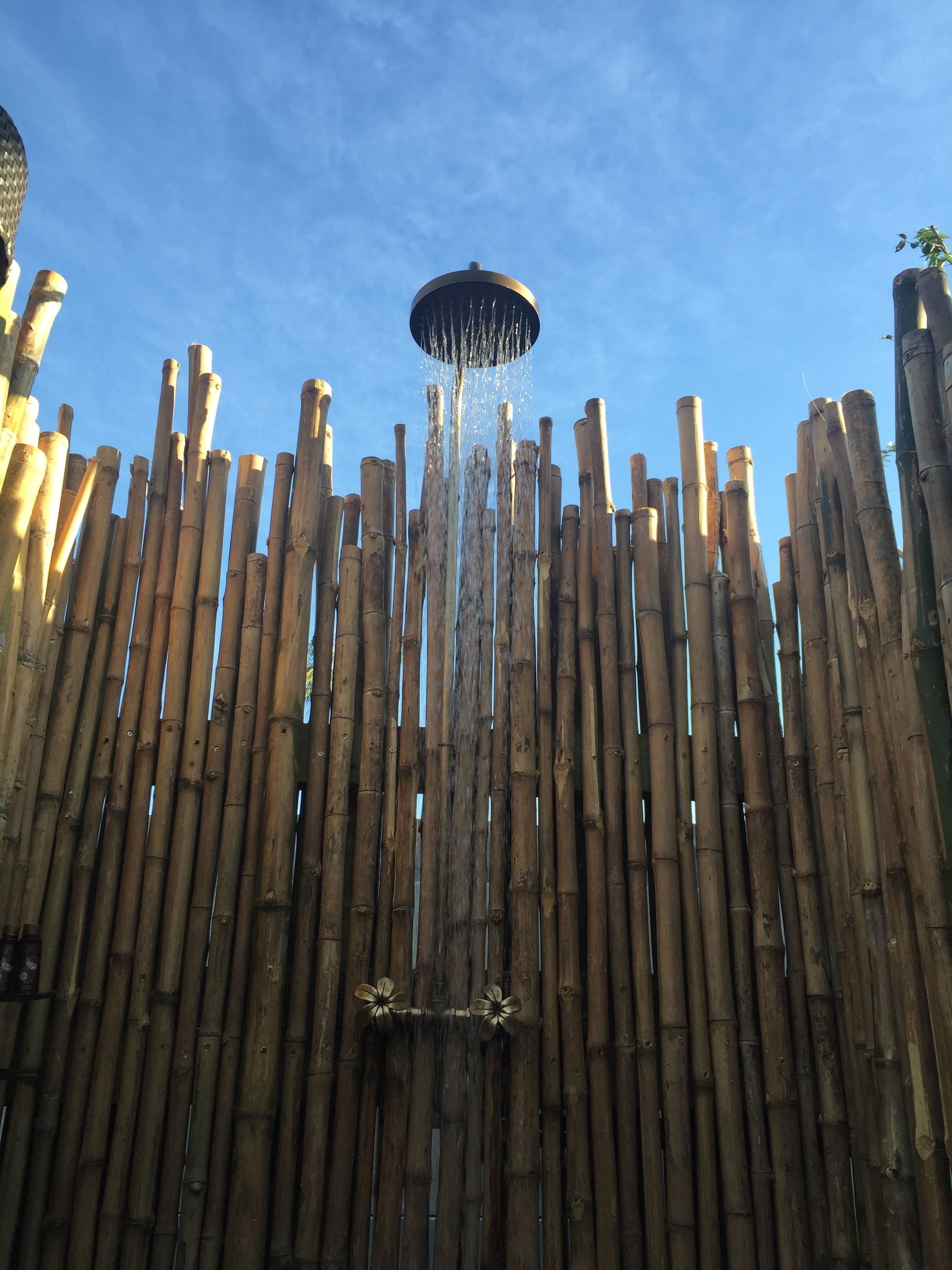 Une clôture en bambou agrémentée d’un élément décoratif aquatique au centre.