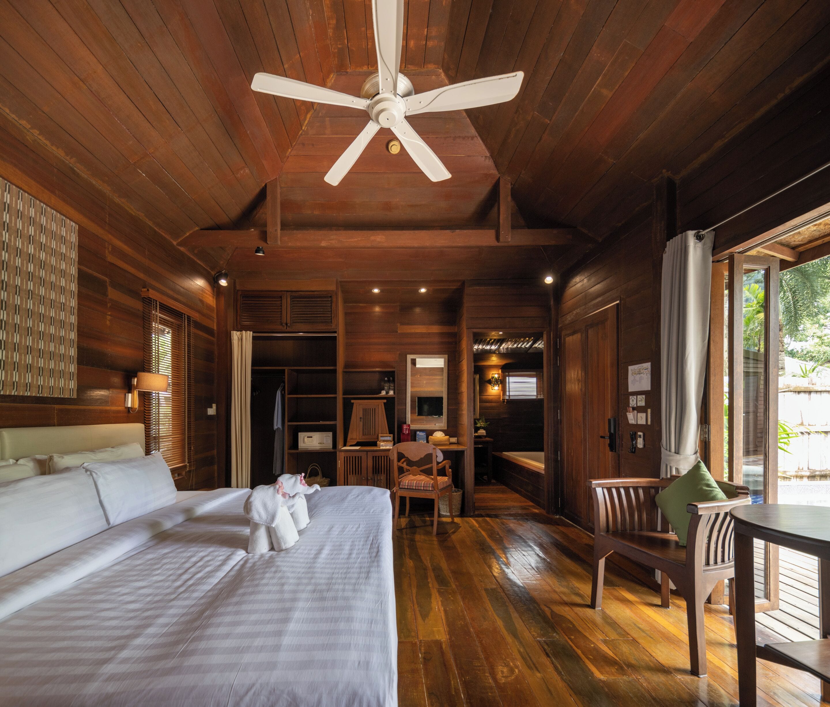 Una habitación de madera con una cama, un escritorio y una silla.