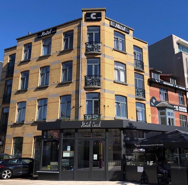 A multi-story hotel with a prominent 'Hotel Cecil' sign at the ground level. - Hotel Cecil (De Panne)