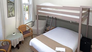 A bunk bed room with a small table, chair, and a window with a view of the beach.