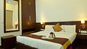 Una habitación de hotel con una cama grande, una mesita de noche, un espejo y un aire acondicionado instalado en la pared.