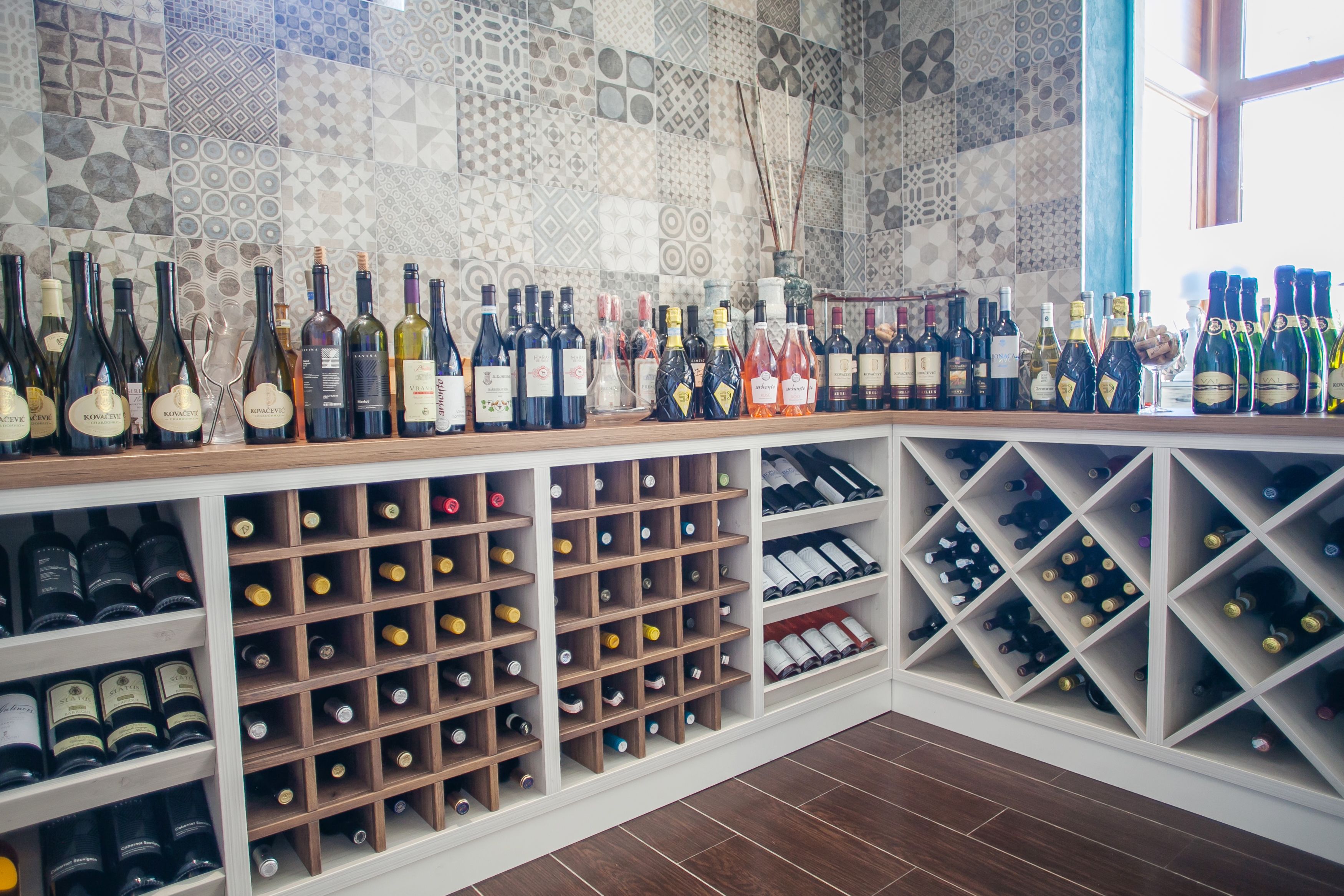 A wine cellar with shelves and racks filled with wine bottles.