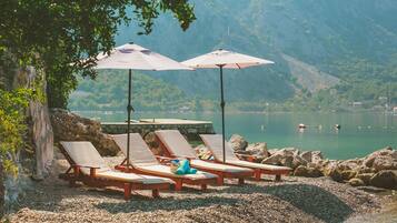 En la playa, camastros y sombrillas