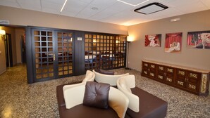 A lobby with a reception desk, seating area, and artwork on the walls. - azuLine Hotel Llevant (Sant Antoni de Portmany)