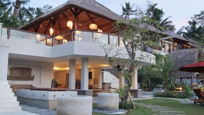 A modern resort with a large open terrace, a thatched-roof structure, and a pool area. - Puri Sebali Resort (Ubud)