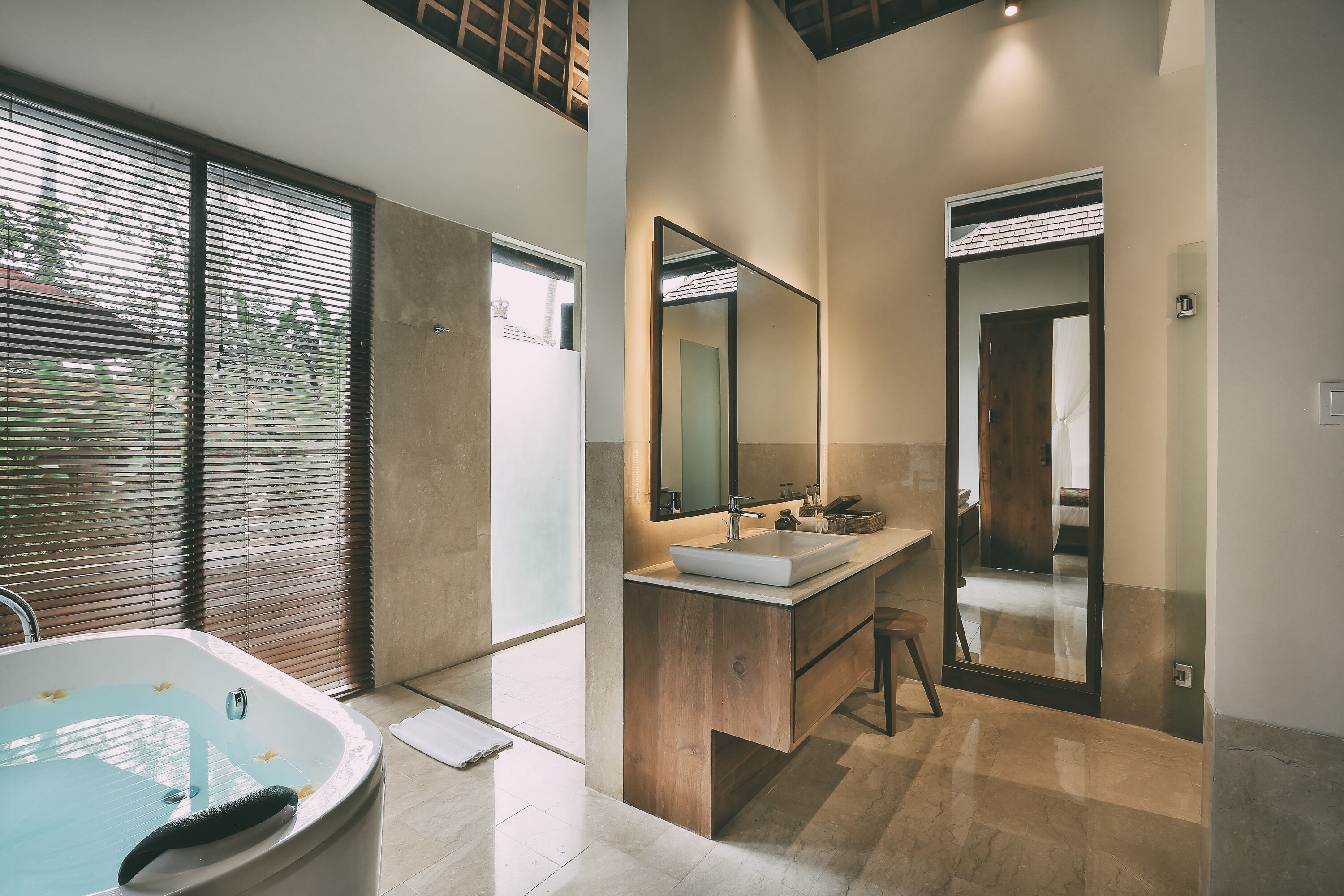 Une salle de bain moderne avec une baignoire sur pieds, un grand miroir et un meuble-lavabo.