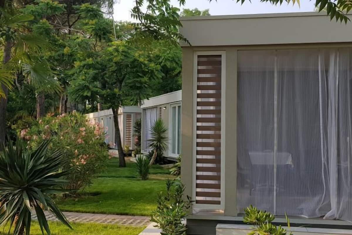 Un edificio moderno con amplias ventanas y un jardín con diversas plantas.