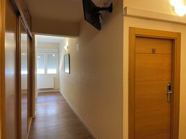 Un pasillo con una puerta de madera marcada con el número 501, un accesorio de iluminación y un radiador.