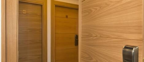 Two wooden doors with numbers 602 and 613, a metallic door handle, and a light fixture above the doors.
