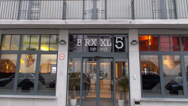 A building with large windows and a sign reading "BRXXL 5 EST. 2013". - BRXXXL5 - Hostel (Brussels)