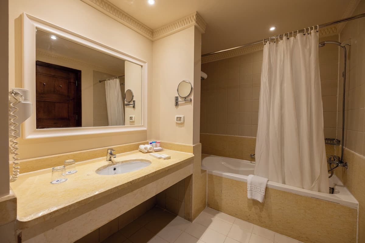 Un baño con lavabo, espejo y bañera.