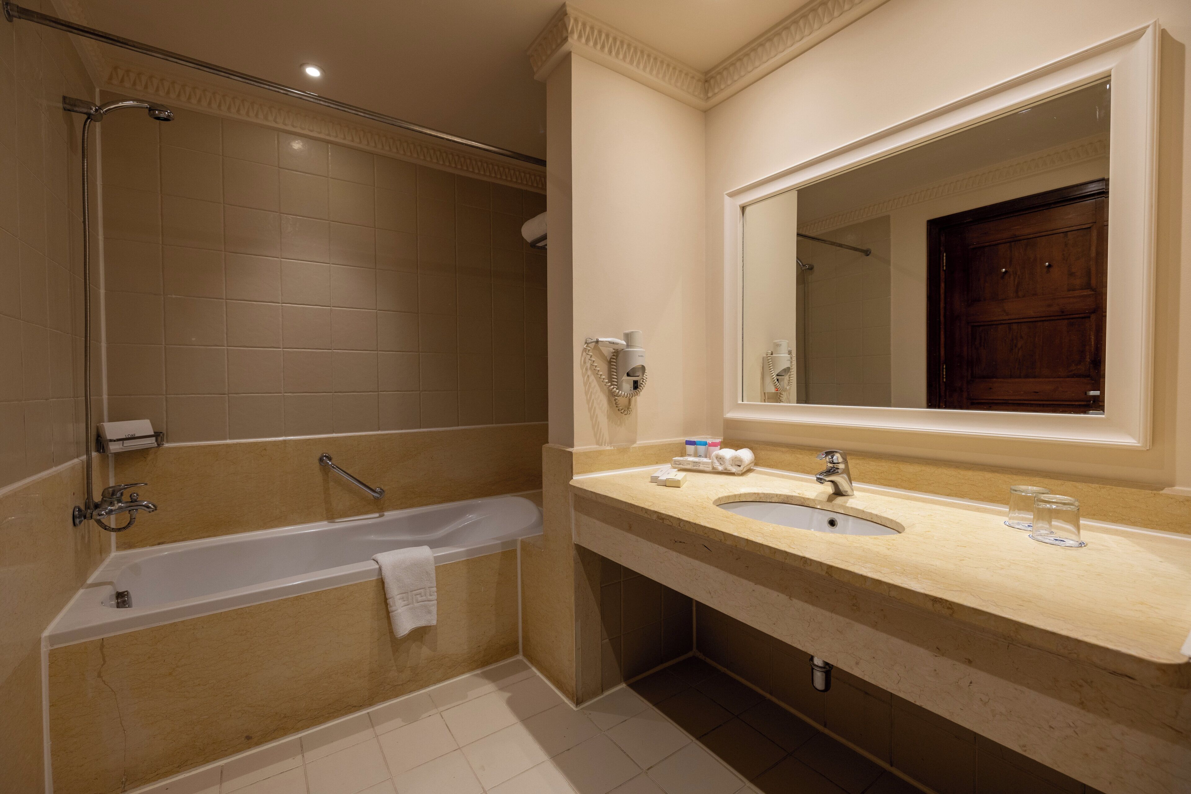 A modern bathroom with a bathtub, a sink, and a large mirror.