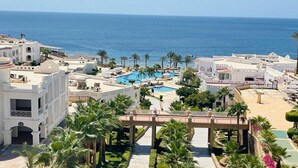 A resort with a central pool, palm trees, and a view of the sea. - Continental Plaza Beach Resort (Sharm El Sheikh)