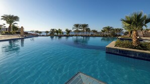 A clear swimming pool with a tiled edge, surrounded by palm trees and a clear sky. - Continental Plaza Beach Resort (Sharm El Sheikh)